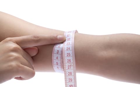 Woman Measuring Wrist With Tape Measure