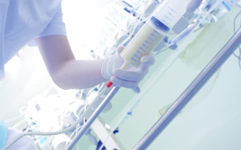 Nurse Holding Syringe With Fluid Inside