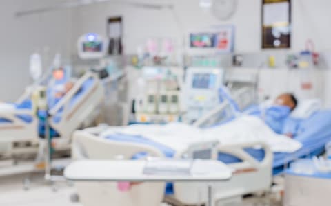 Patients Laying In Hospital Beds On Ward