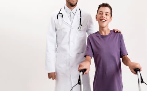 Less Abled Boy On Zimmer Frame With Doctor