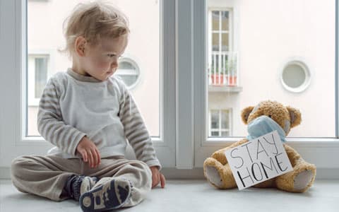 Toddler Sat Next To Bear With Stay At Home Sign Attached