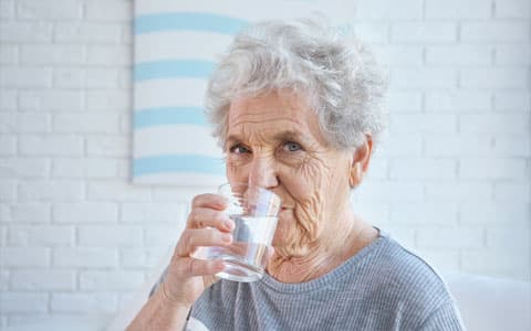 Elderly Woman Drinking Glass Of Water