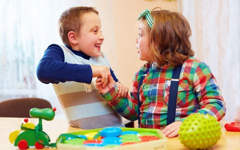 Kids Playing Together At Table And Holding Hands